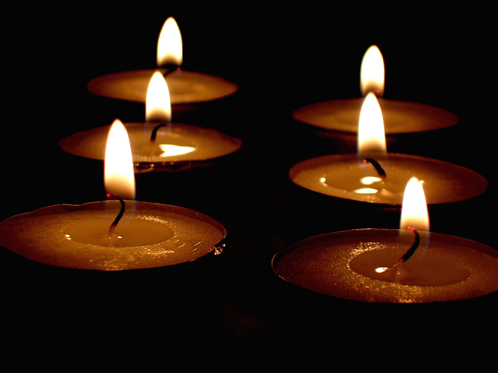 several burning tea lights sitting side by side