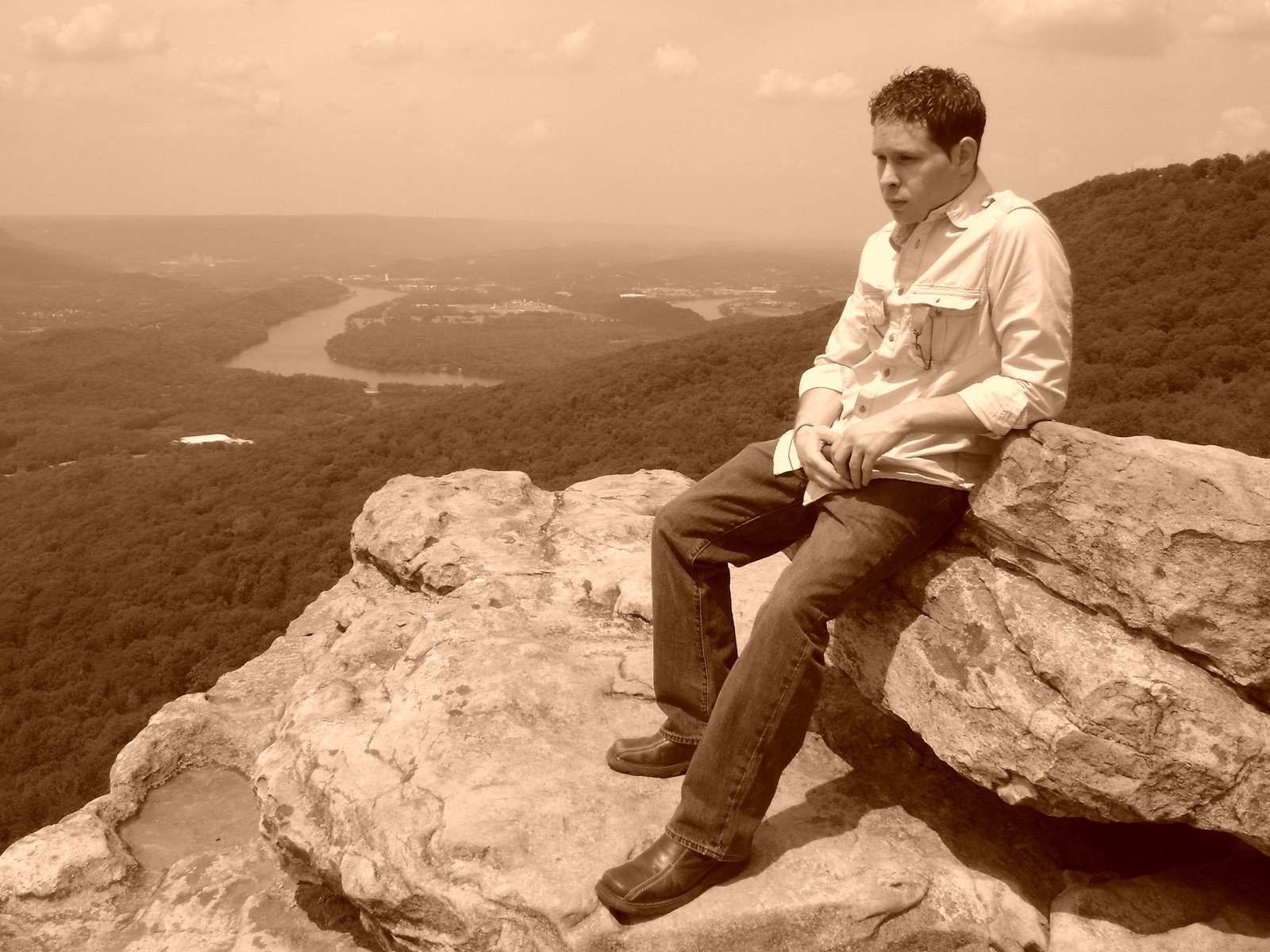 a person sitting on a rock looking into the distance