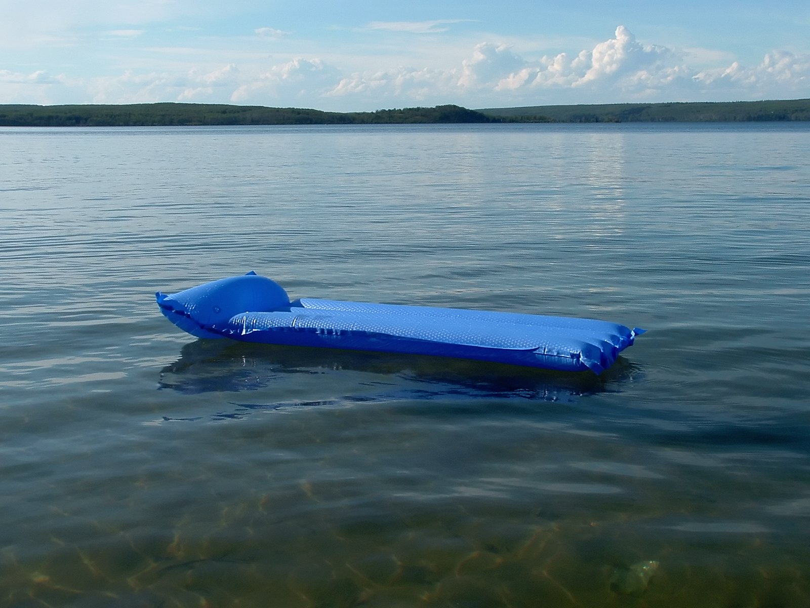 a blue board floating on a lake next to an island