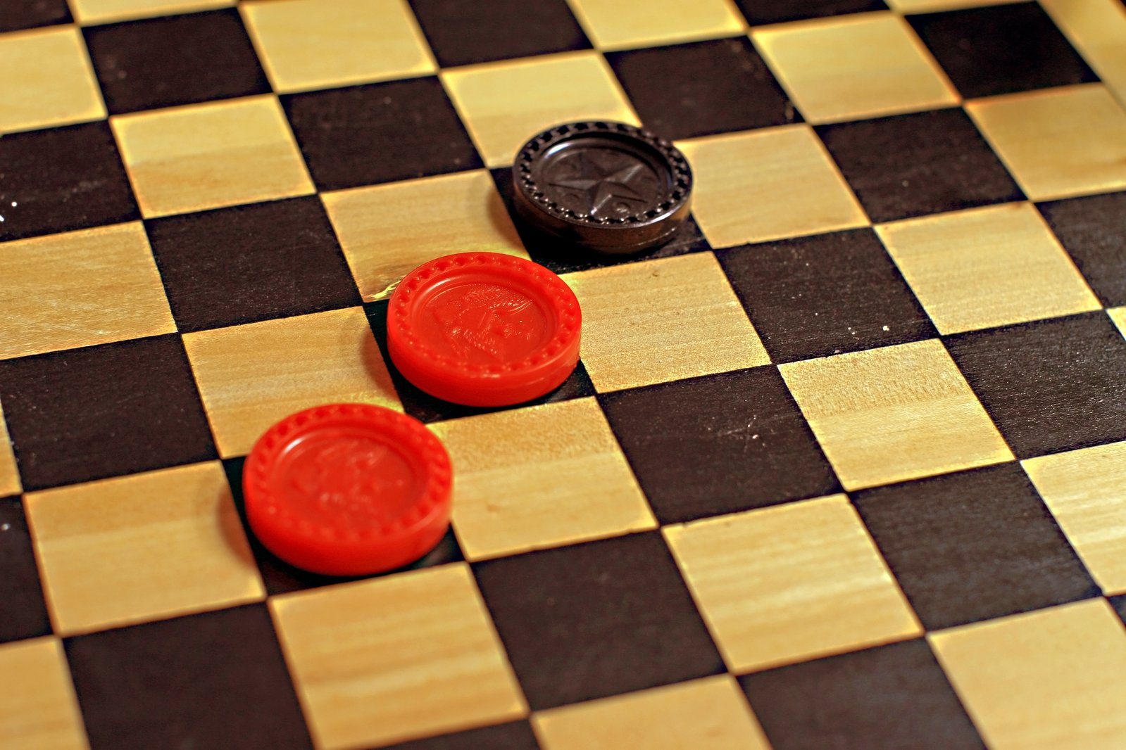 two red rubber discs sitting on a black and white checkered board