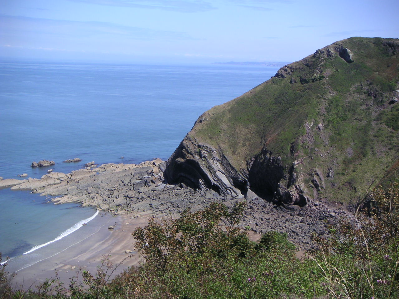 two mountain sides on the edge of a body of water