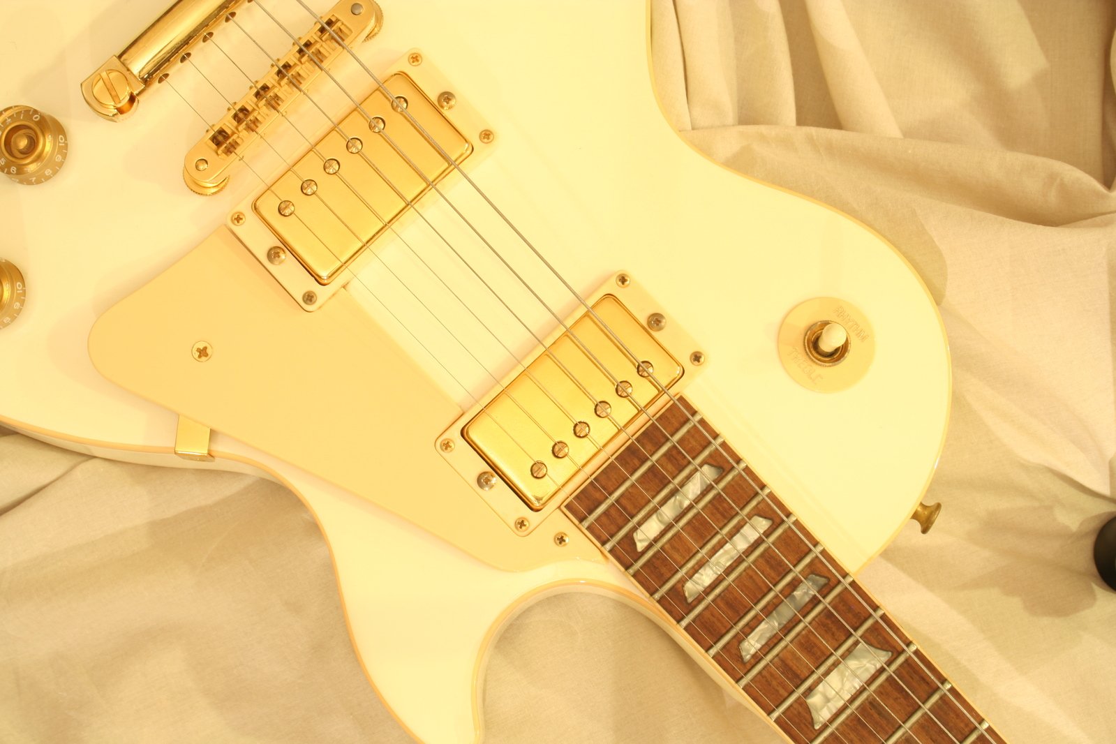 a yellow guitar sits on its side with a white background