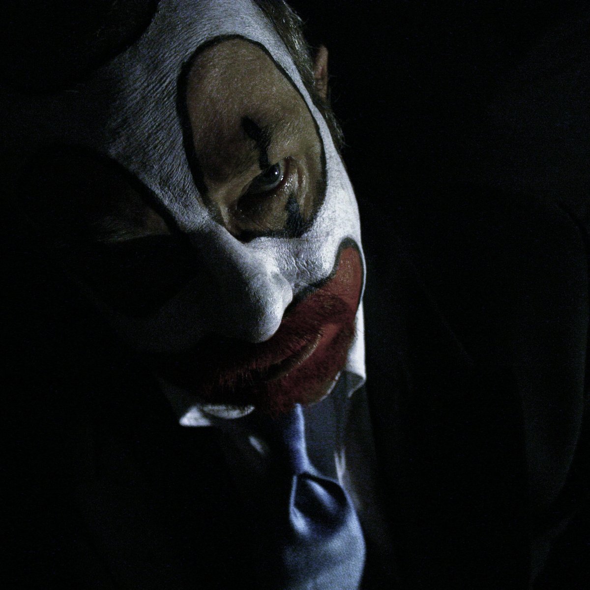 a person in a white mask with a tie