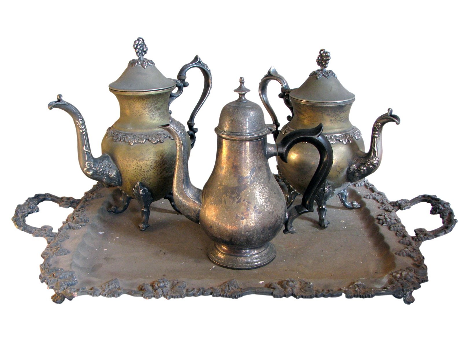 a group of metallic tea pots and kettles on a cloth