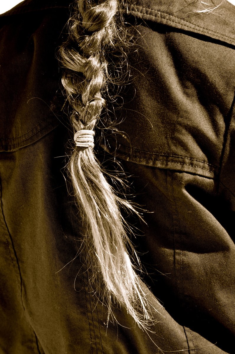 an up - close view of a shirt with hair pinned in a ribbon
