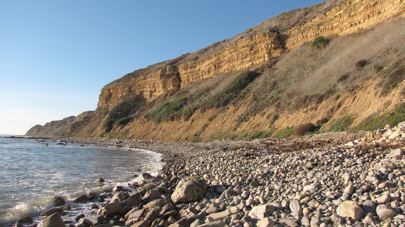 an area with some rocks and water in the foreground