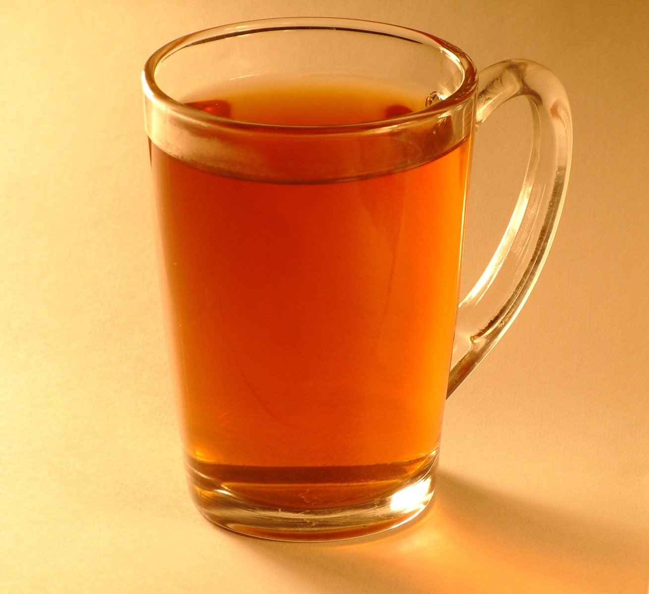 a glass tea cup with tea is shown in the sunlight