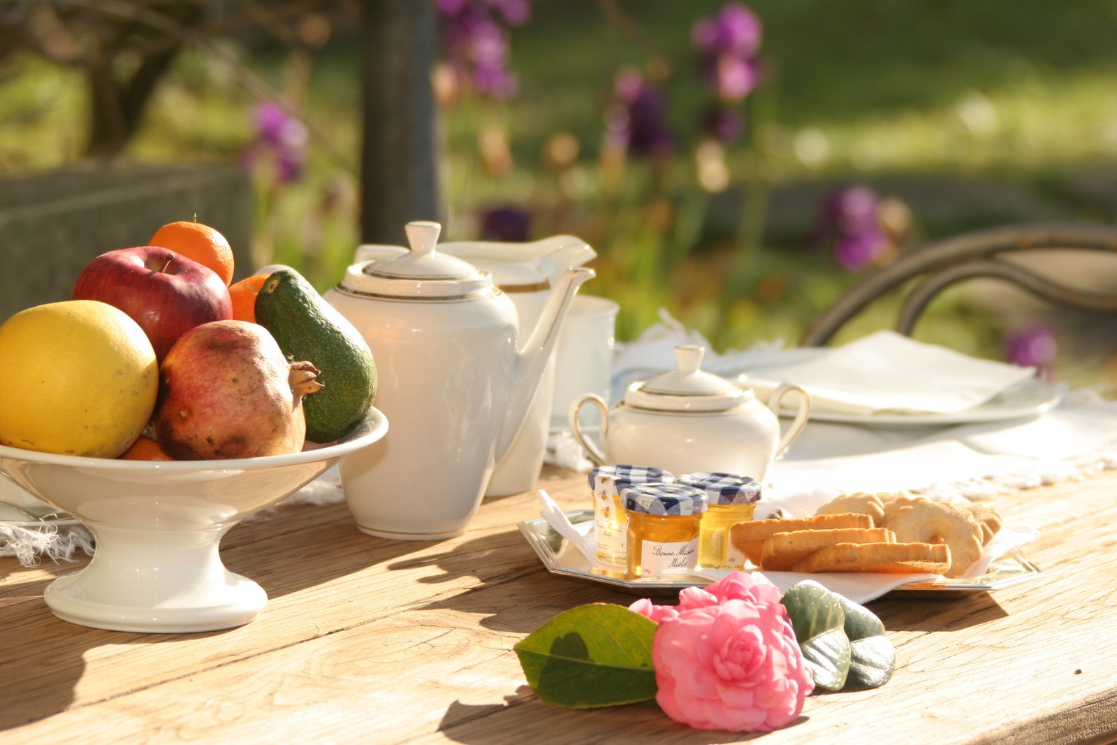 fresh fruit sitting on a table with tea pots and dishes