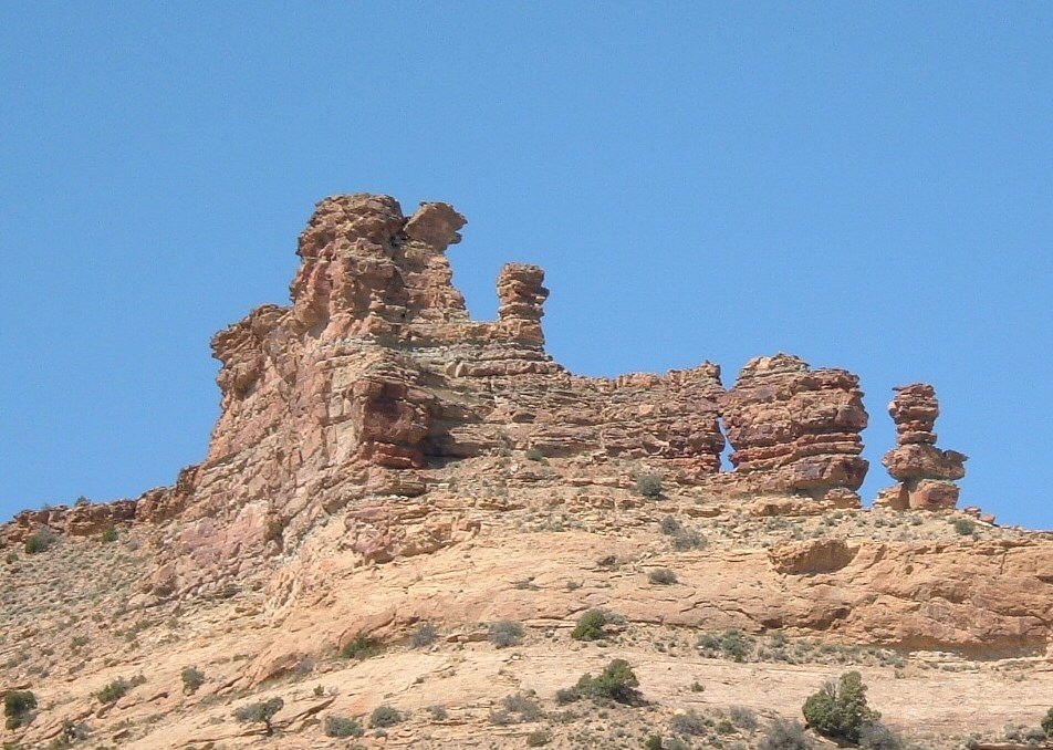 several rock formations and shrubs in the desert