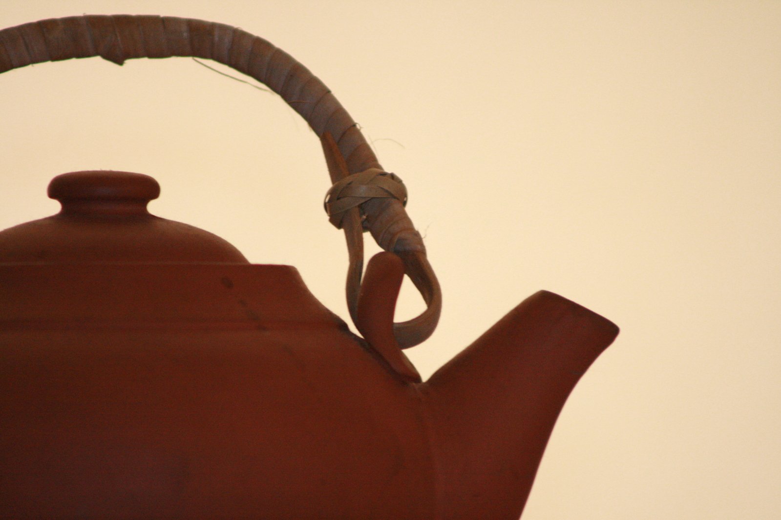 a brown metal kettle with a twisted handle