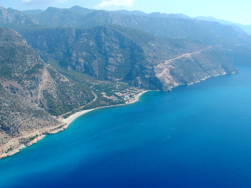 a small plane is flying over a blue mountain