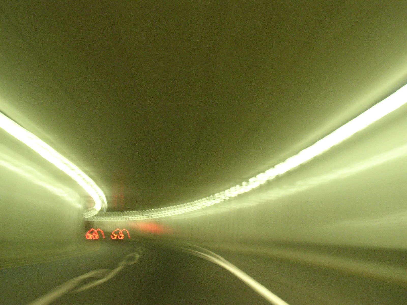 a car driving down a tunnel with a light that reads on it