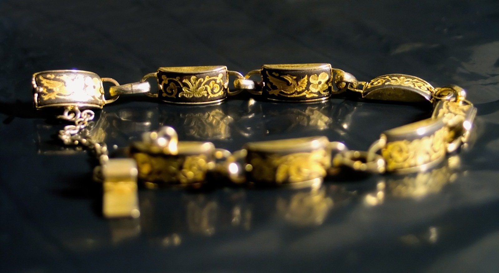 a yellow and gold celet sitting on top of a black table