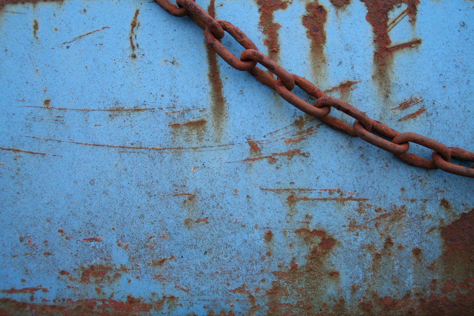 an old rusty rusty chain attached to the side of a blue truck