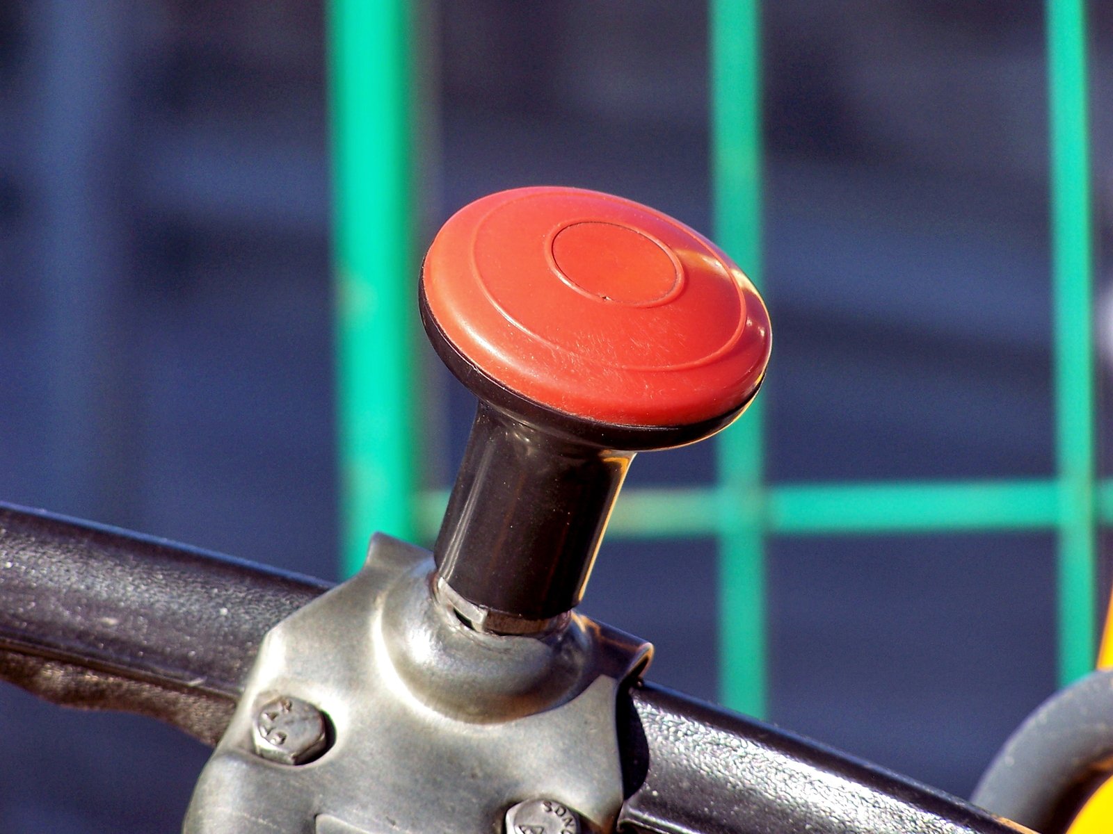 a yellow motorcycle parked behind a metal bar with red on