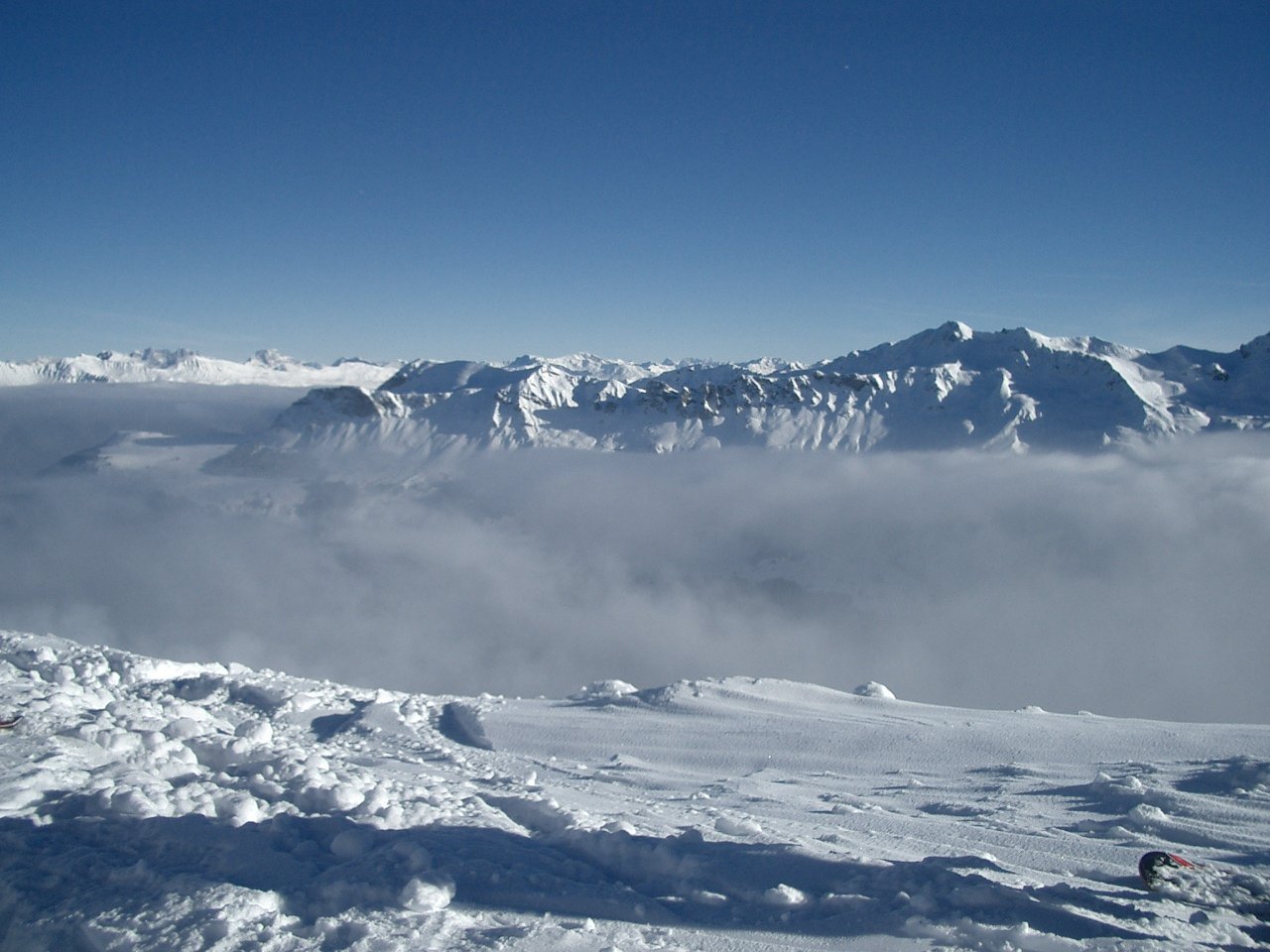 there are snow - capped mountains that are covered by low lying clouds