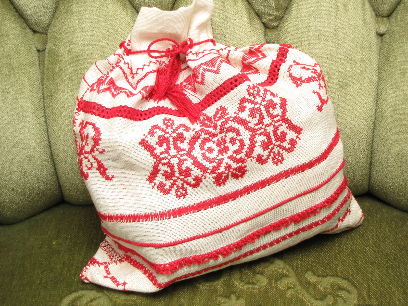 a white bag with a red design sitting on top of a green chair