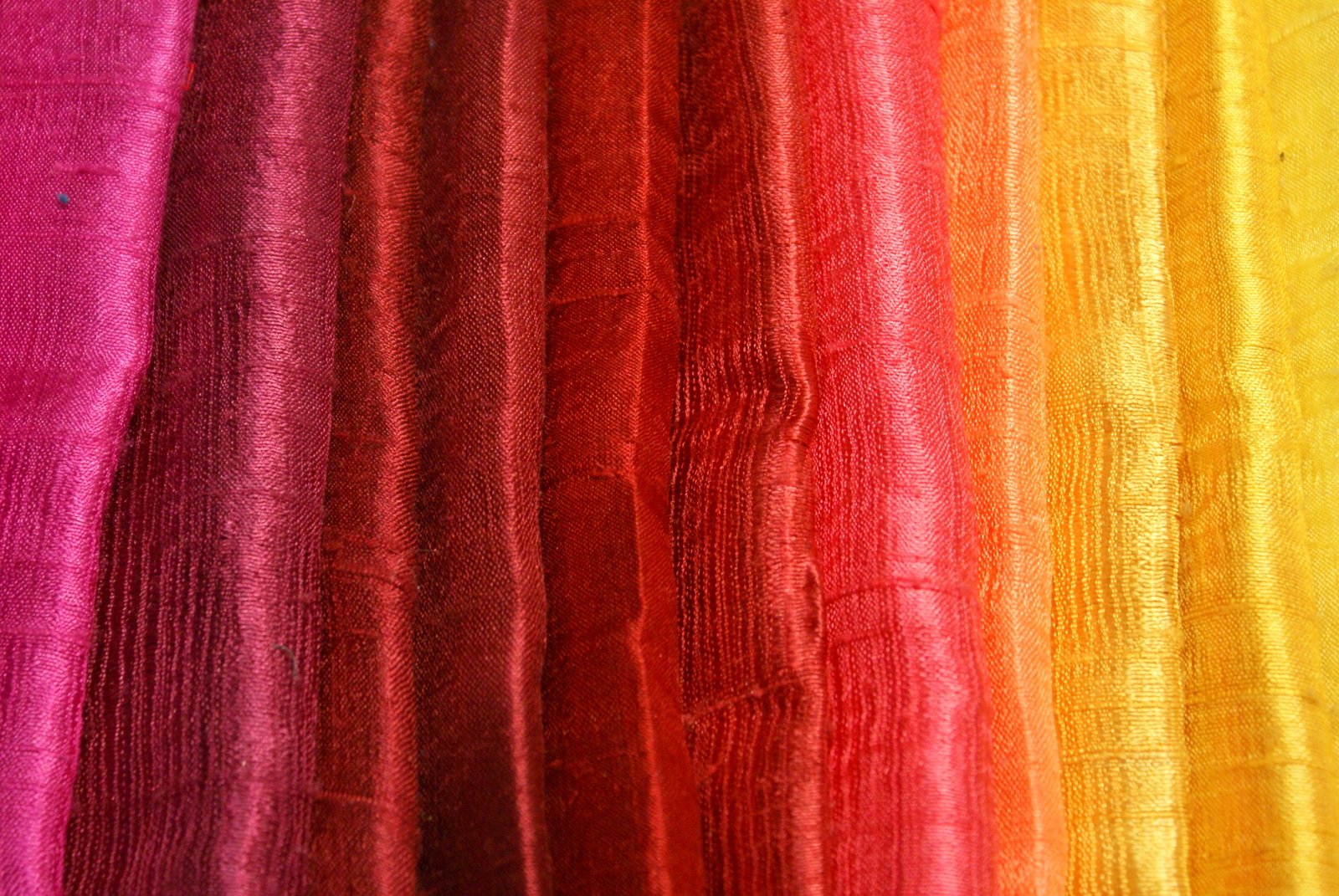 a group of colored sheets with a close up po of one of the curtains