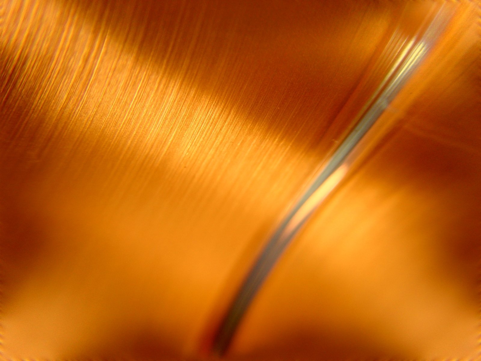 a brown plate with metal handles has a silver spoon in it