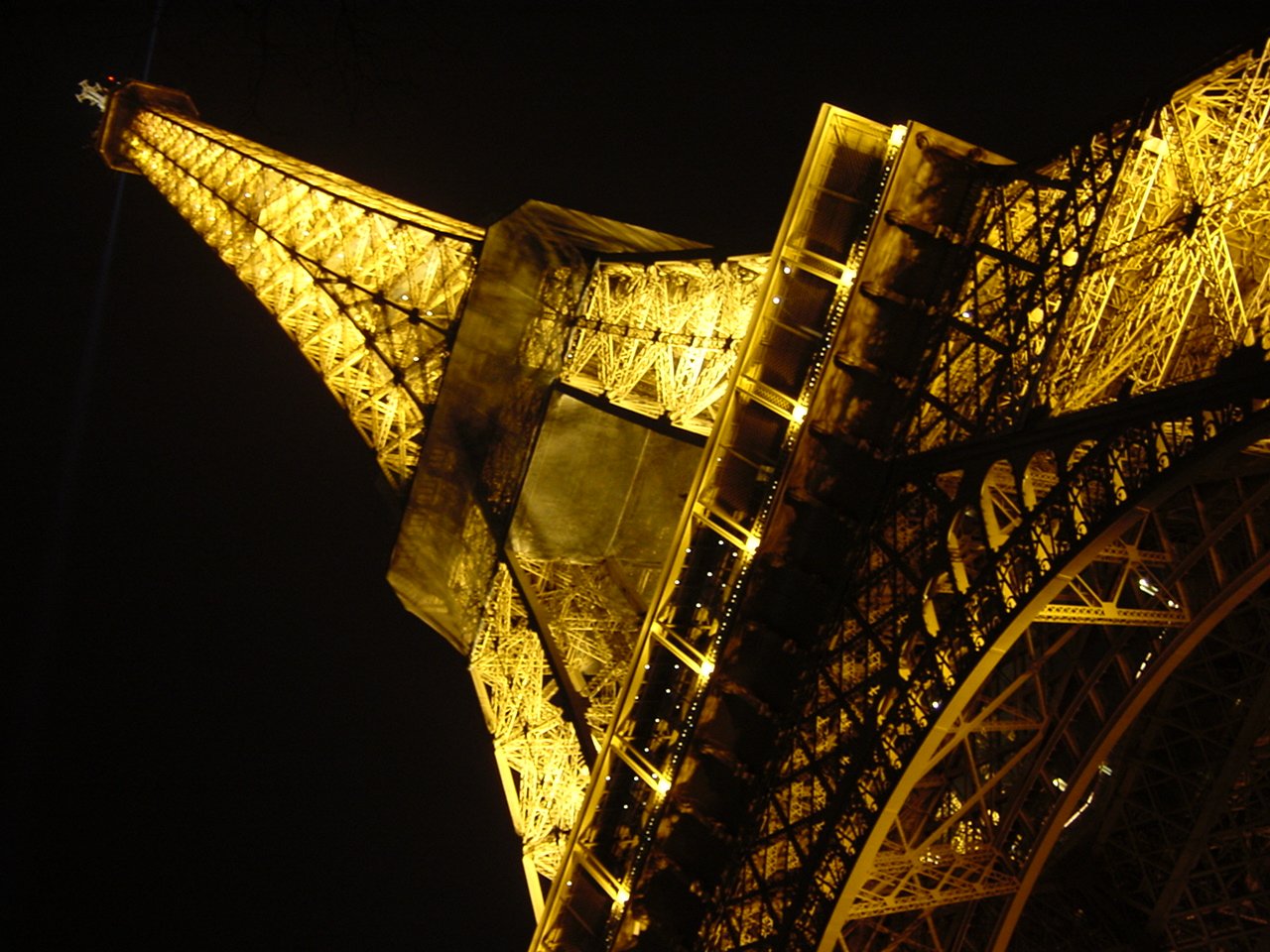 the illuminated eiffel tower is visible from below