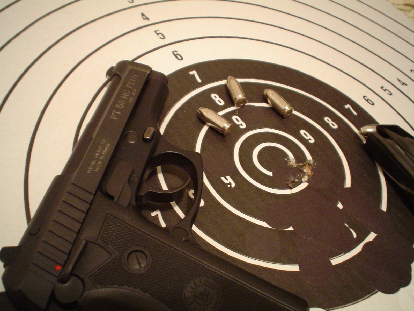 a gun sitting on top of a target surrounded by bullet holes