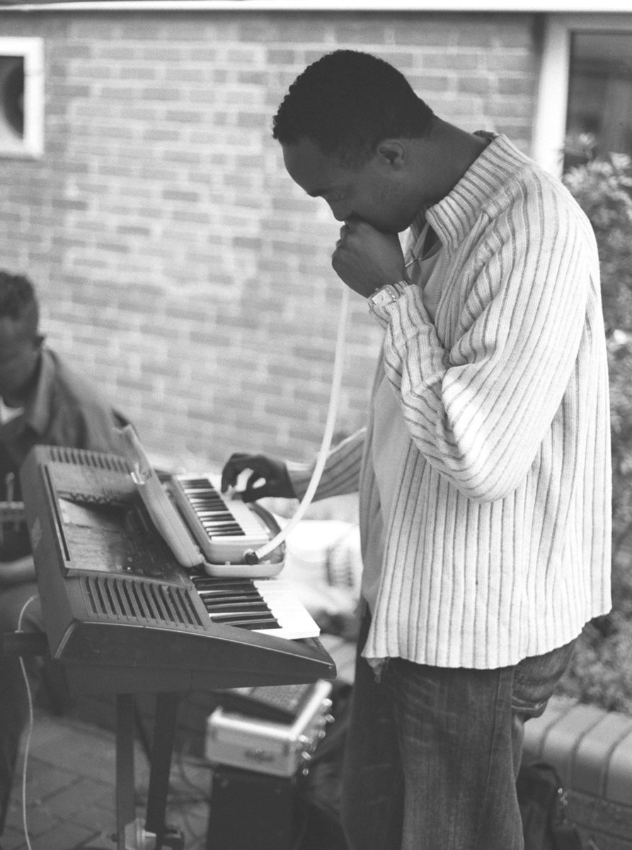 a black and white po of a person with a cell phone in front of a keyboard