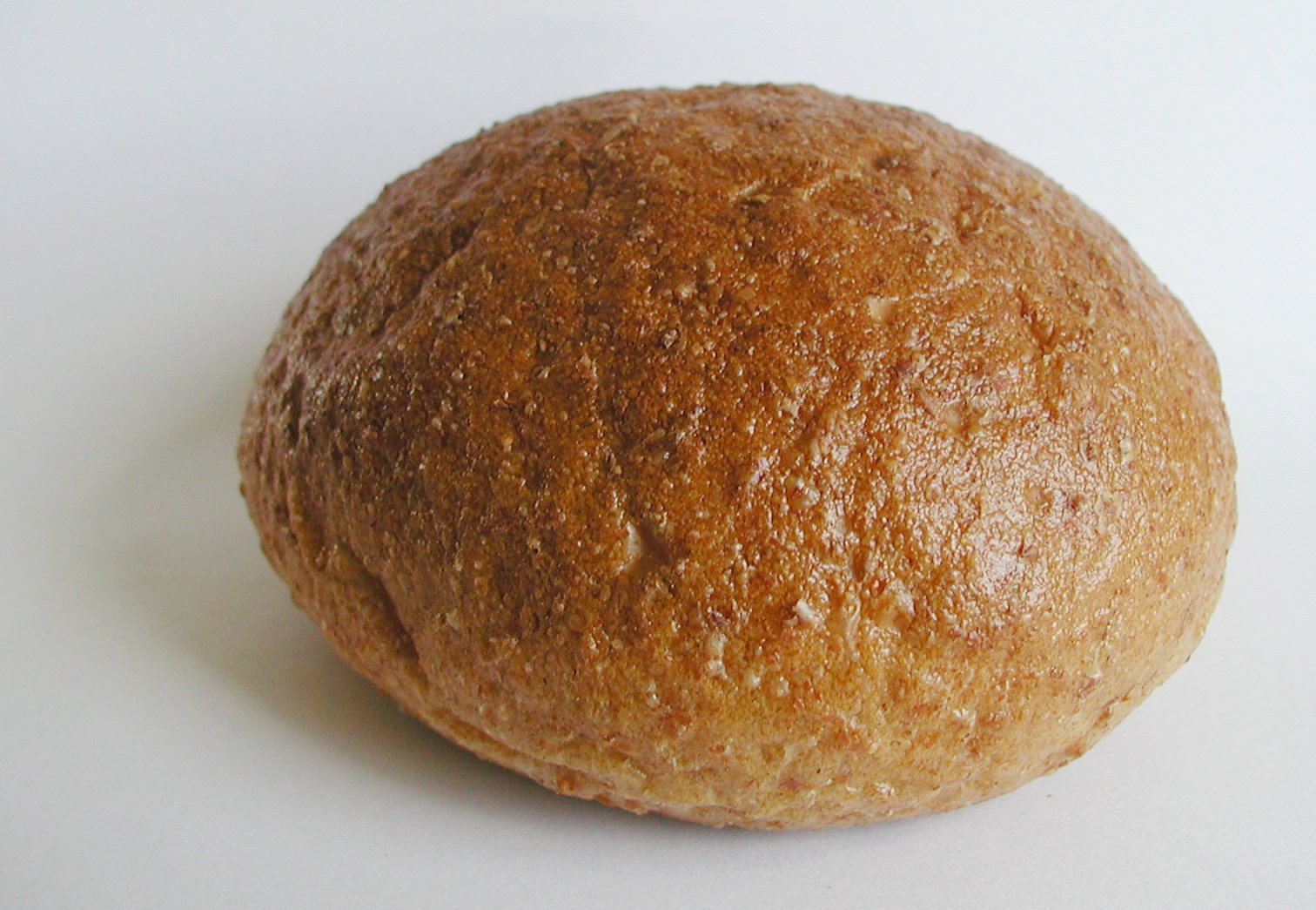 a large round loaf of bread on a white surface