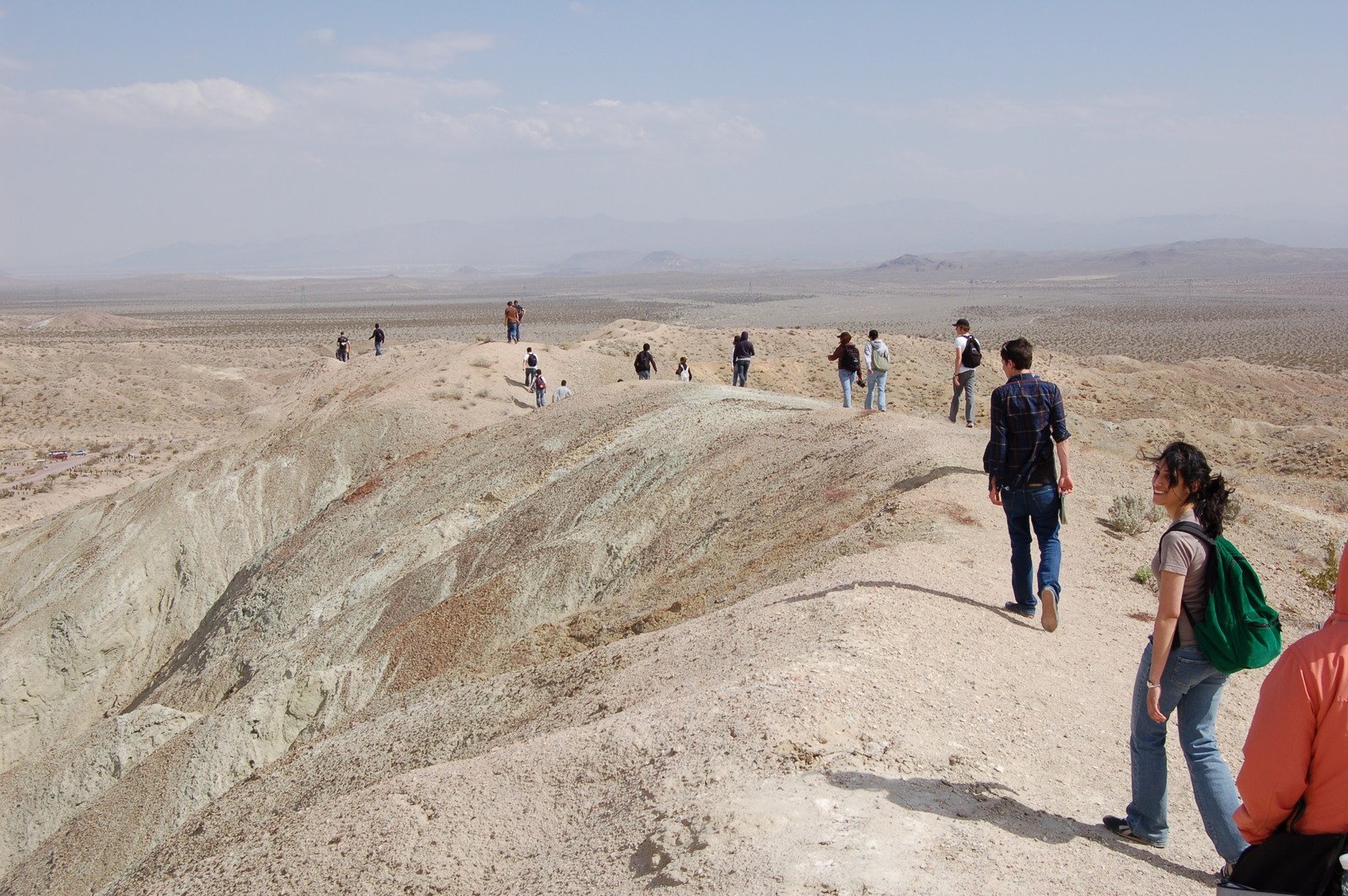 the group of people are walking down the hill