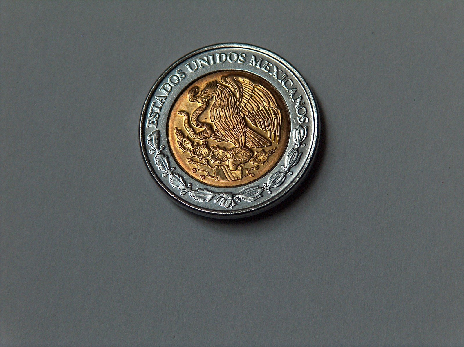 a canadian 1 cent gold coin is shown in front of a gray background