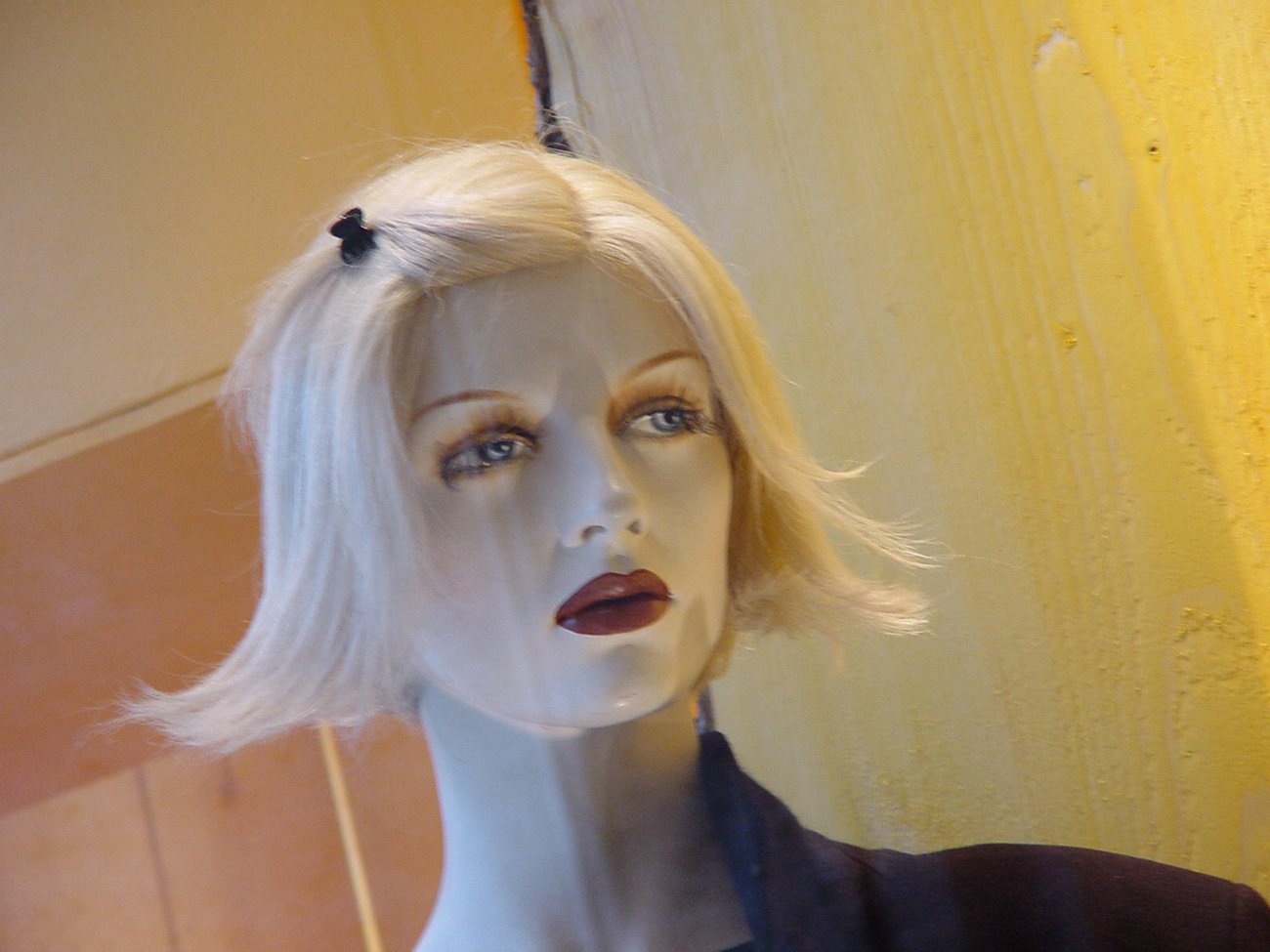 a mannequin wig with a black flower on it