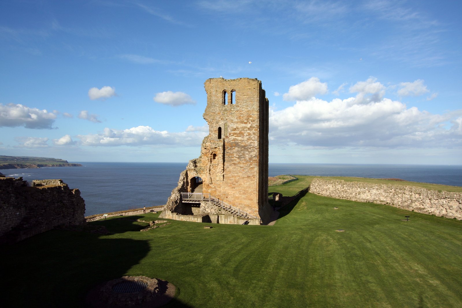 the view of an ancient stone tower by the sea