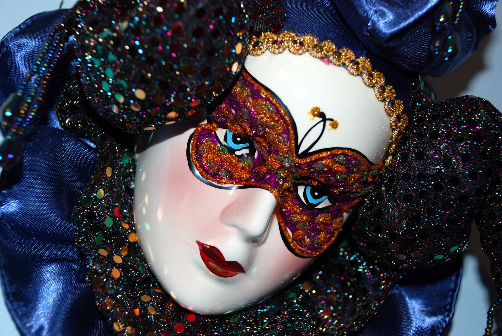 a woman wearing a mask with colorful beads and jewels