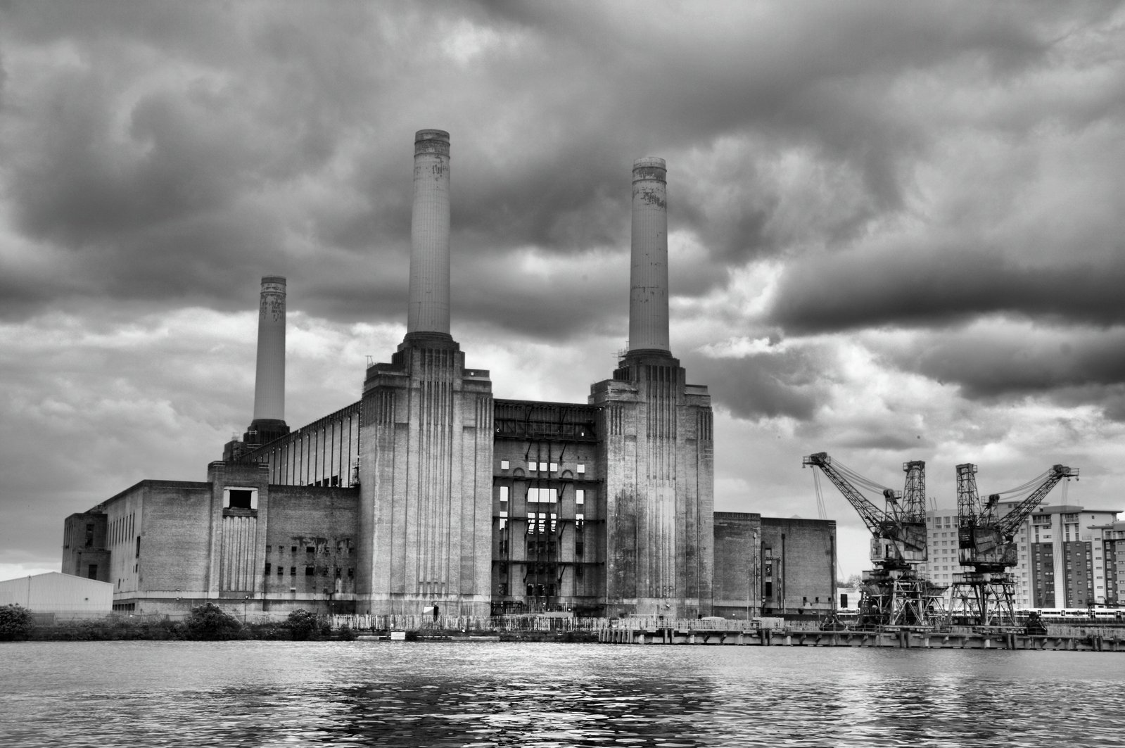 an industrial power plant surrounded by water with cloudy skies