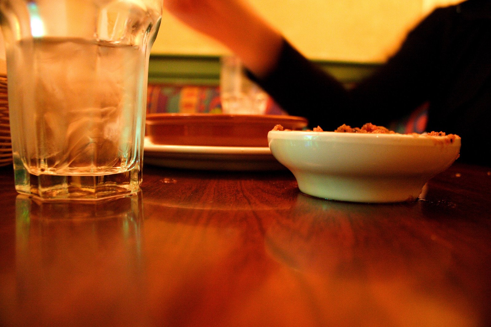 a man sits at a wooden table with two glasses