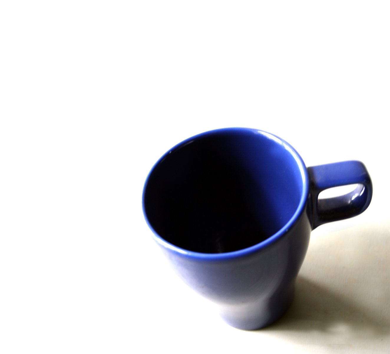 the white and blue coffee mug sits on a table