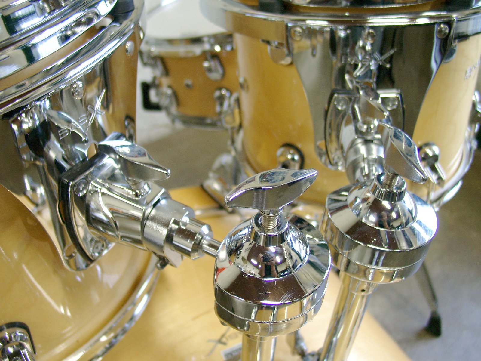 a yellow drum set with chrome hardware and a shiny chrome band