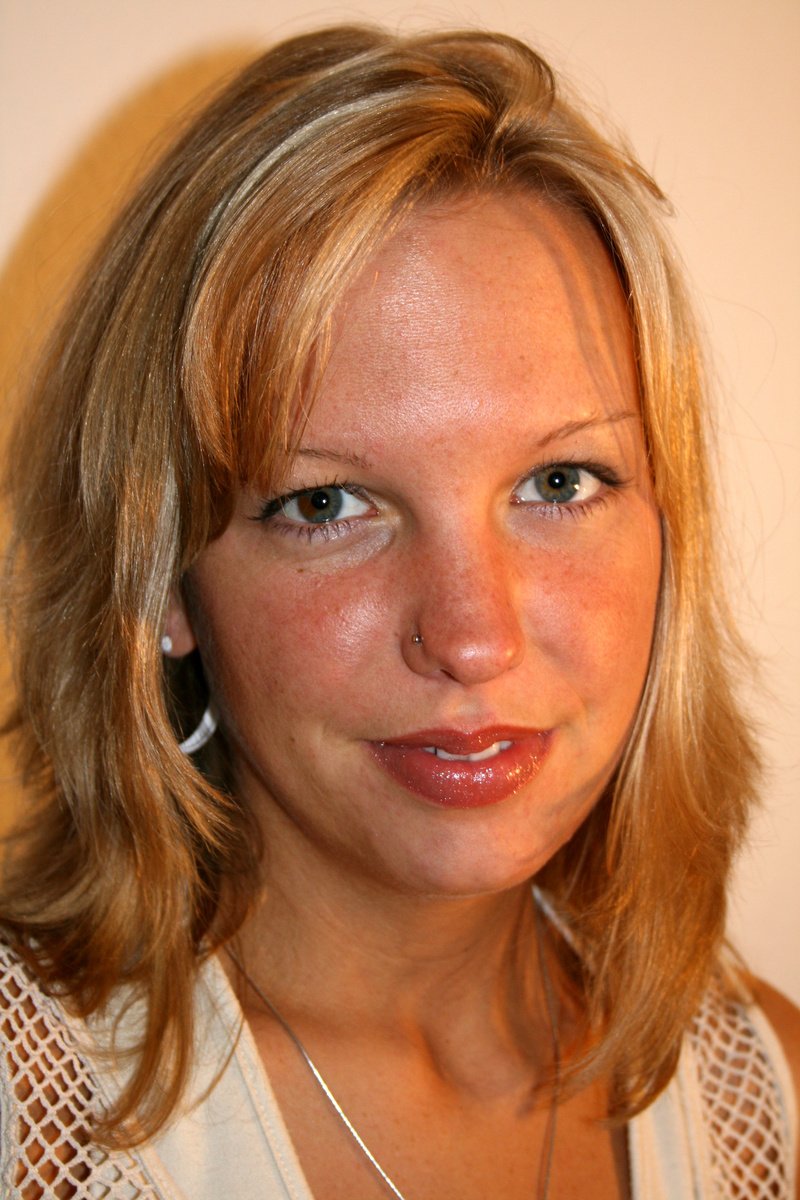 woman in white blouse wearing hoop earrings and staring