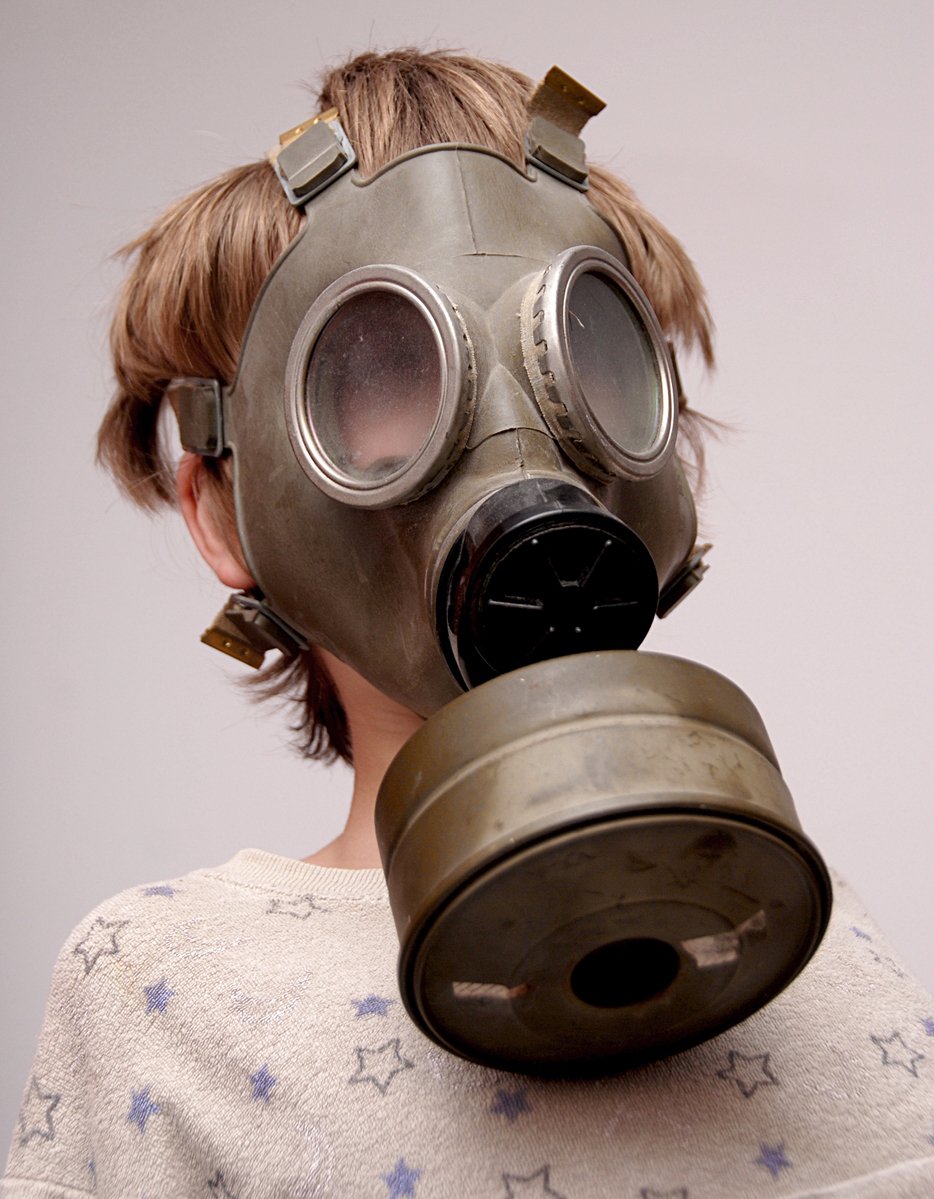 girl wearing a gas mask to hear through a metal whistle