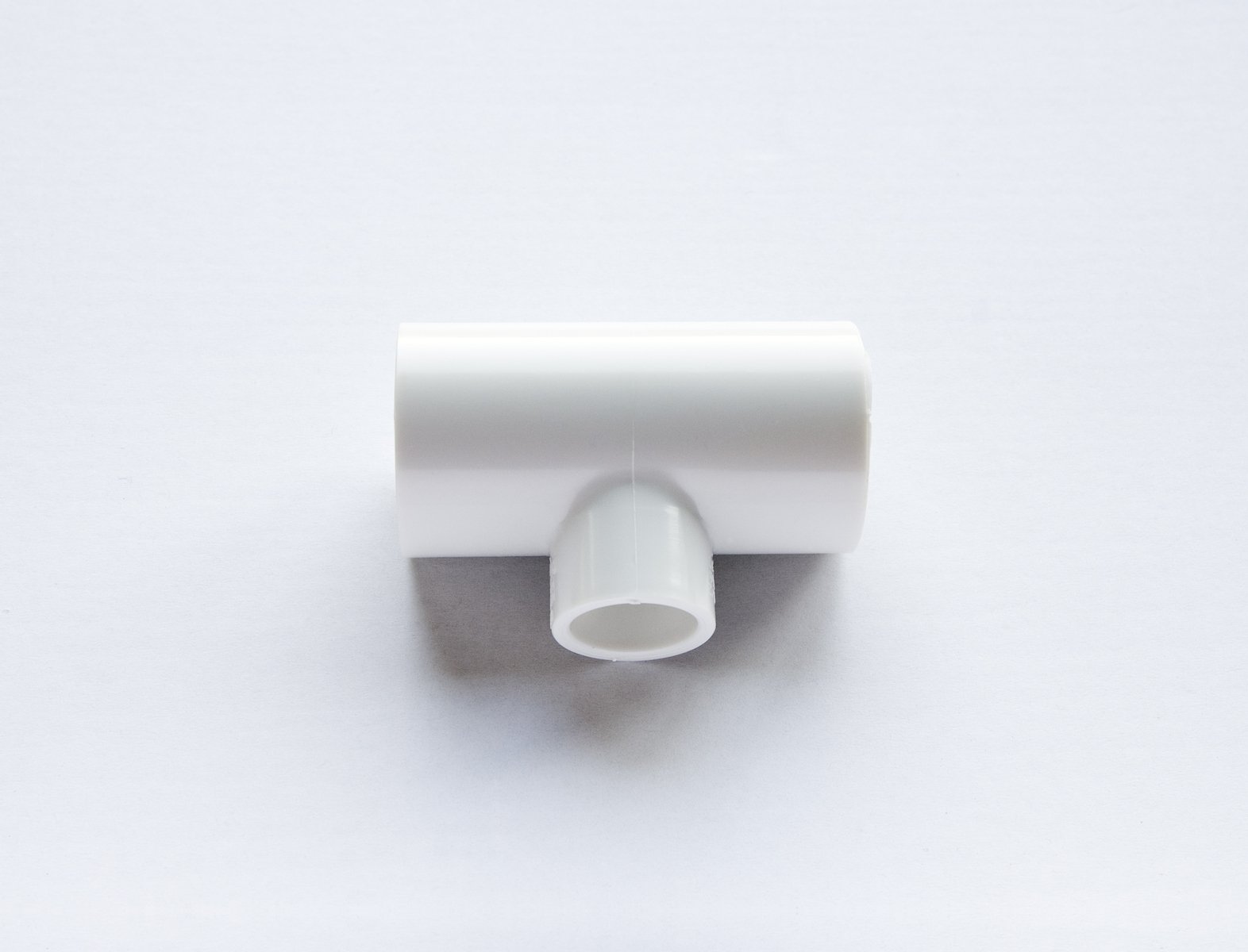 a single white plastic object with a curved tube