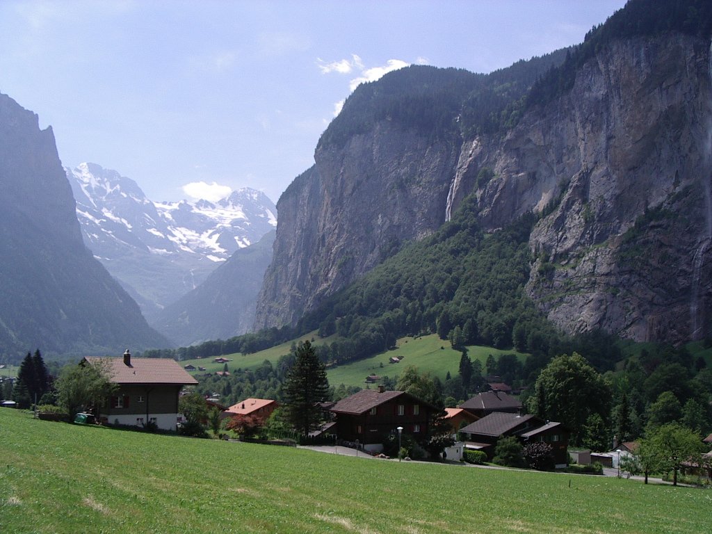 houses in a village in a valley with snowy mountains