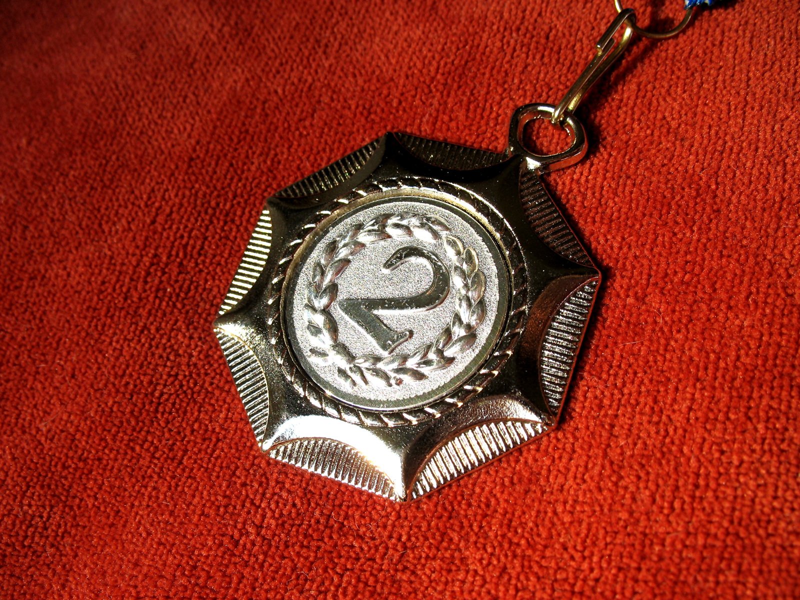 the emblem of a red cloth is hanging on a key chain