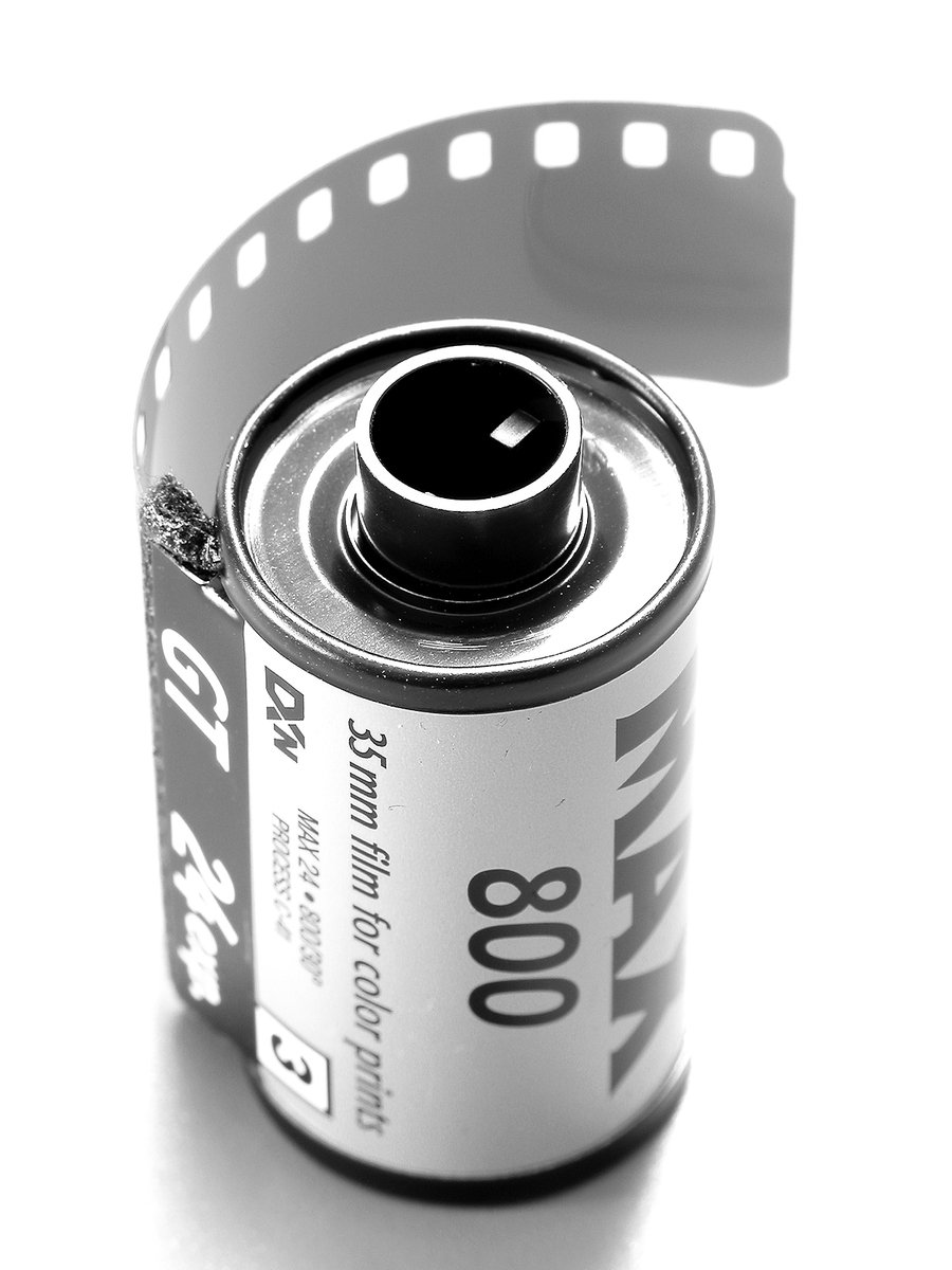 an open can of drink sitting on top of a film roll