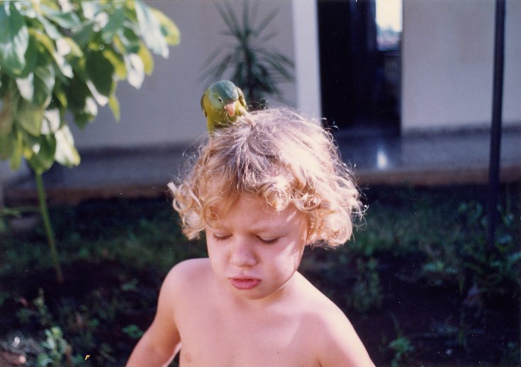 a boy is holding his shirt off with an object on top
