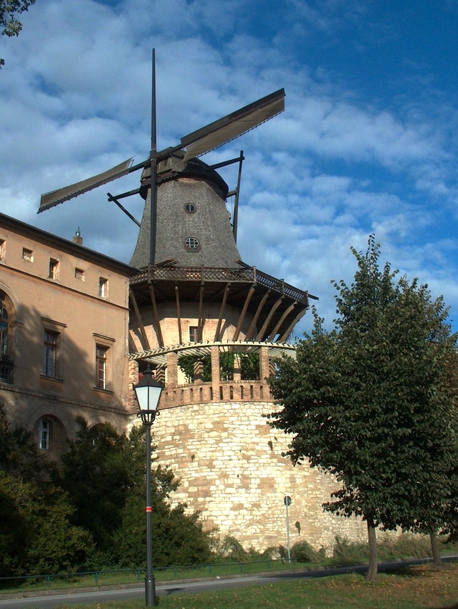 a windmill is on display near an old brick building
