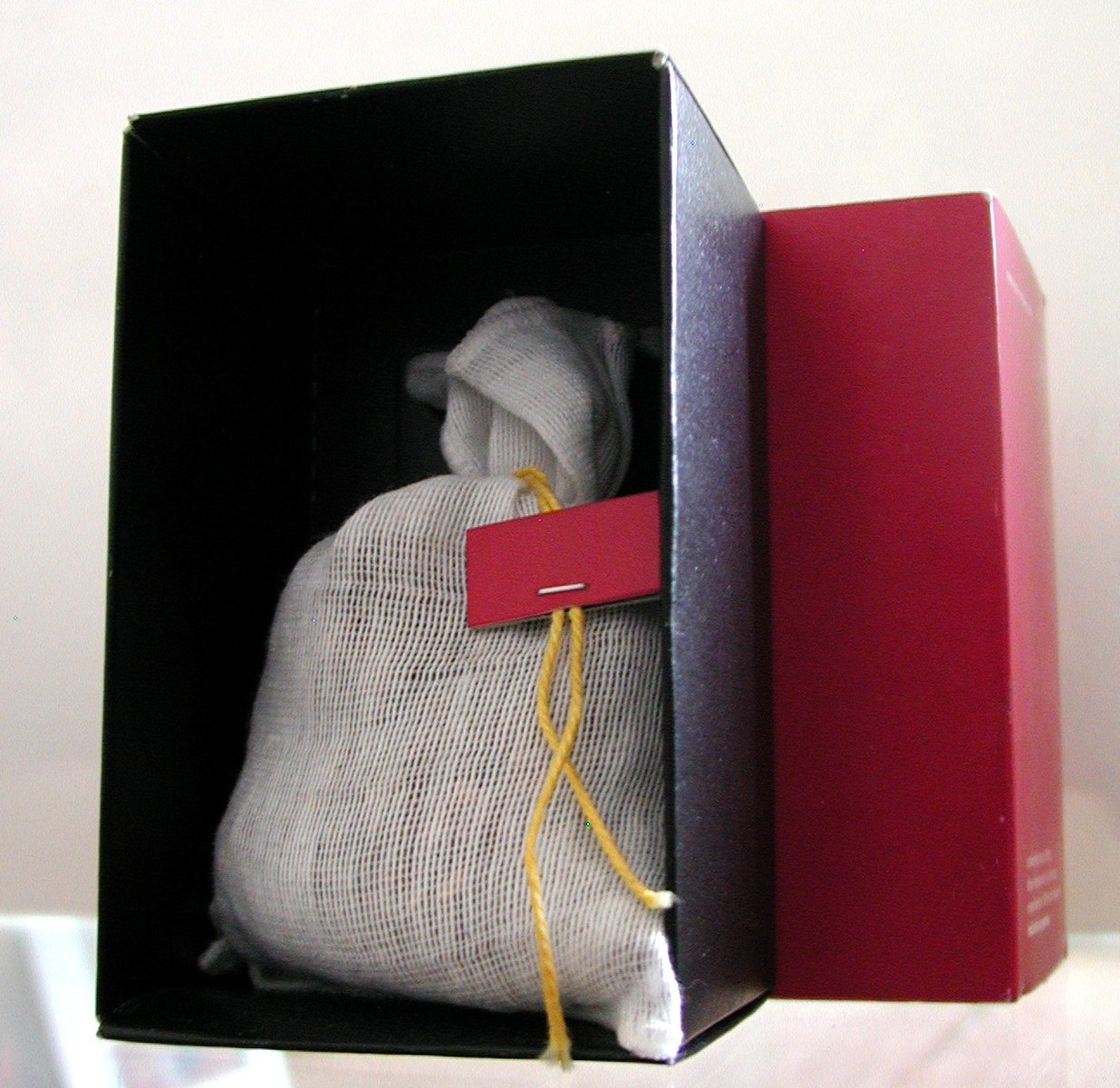 a small black box holds a cloth with a red tag in it