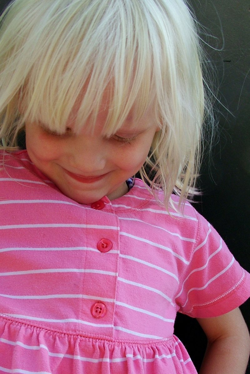 small blonde girl with pink shirt and white  skirt