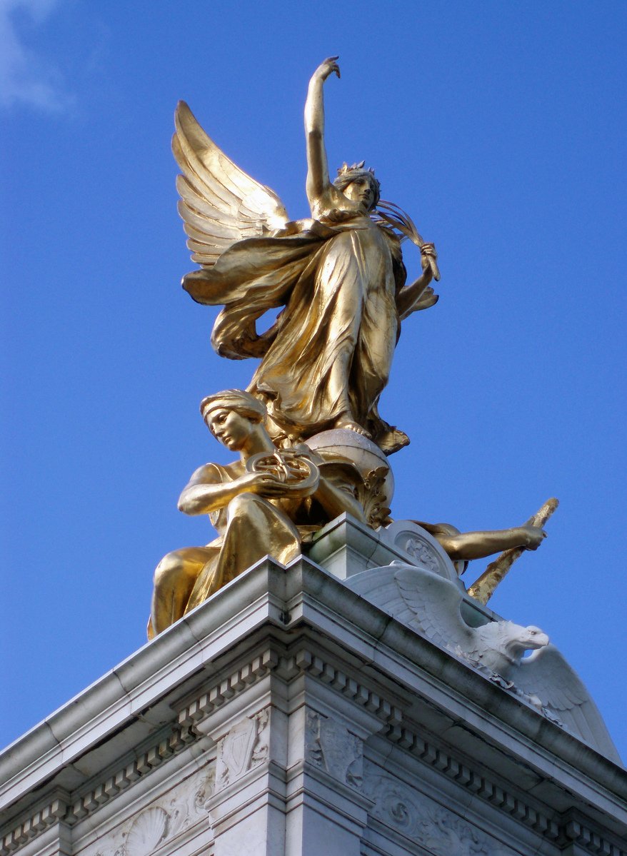 the gilded statue atop of the monument shows a woman with an umbrella