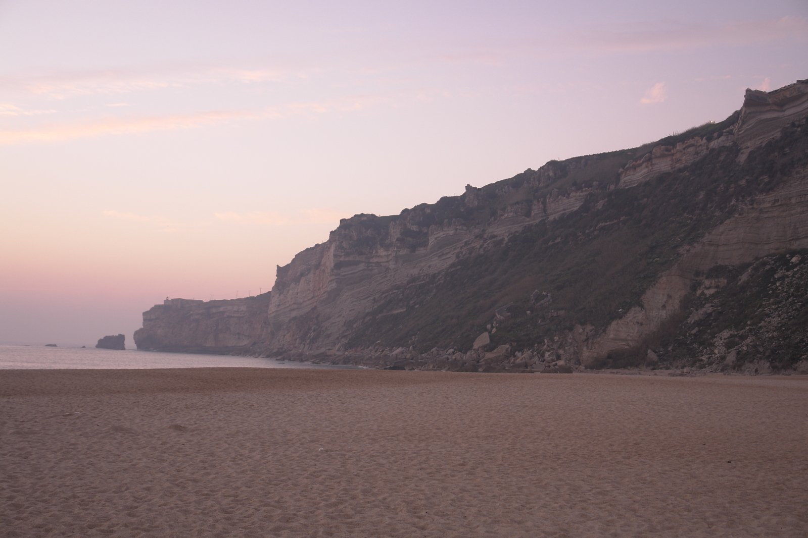 the beach has a bunch of cliffs in the distance