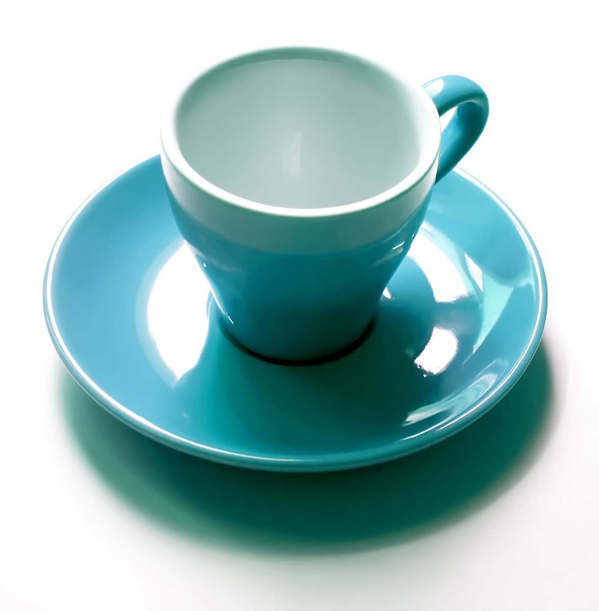 a tea cup and saucer with spoon on plate