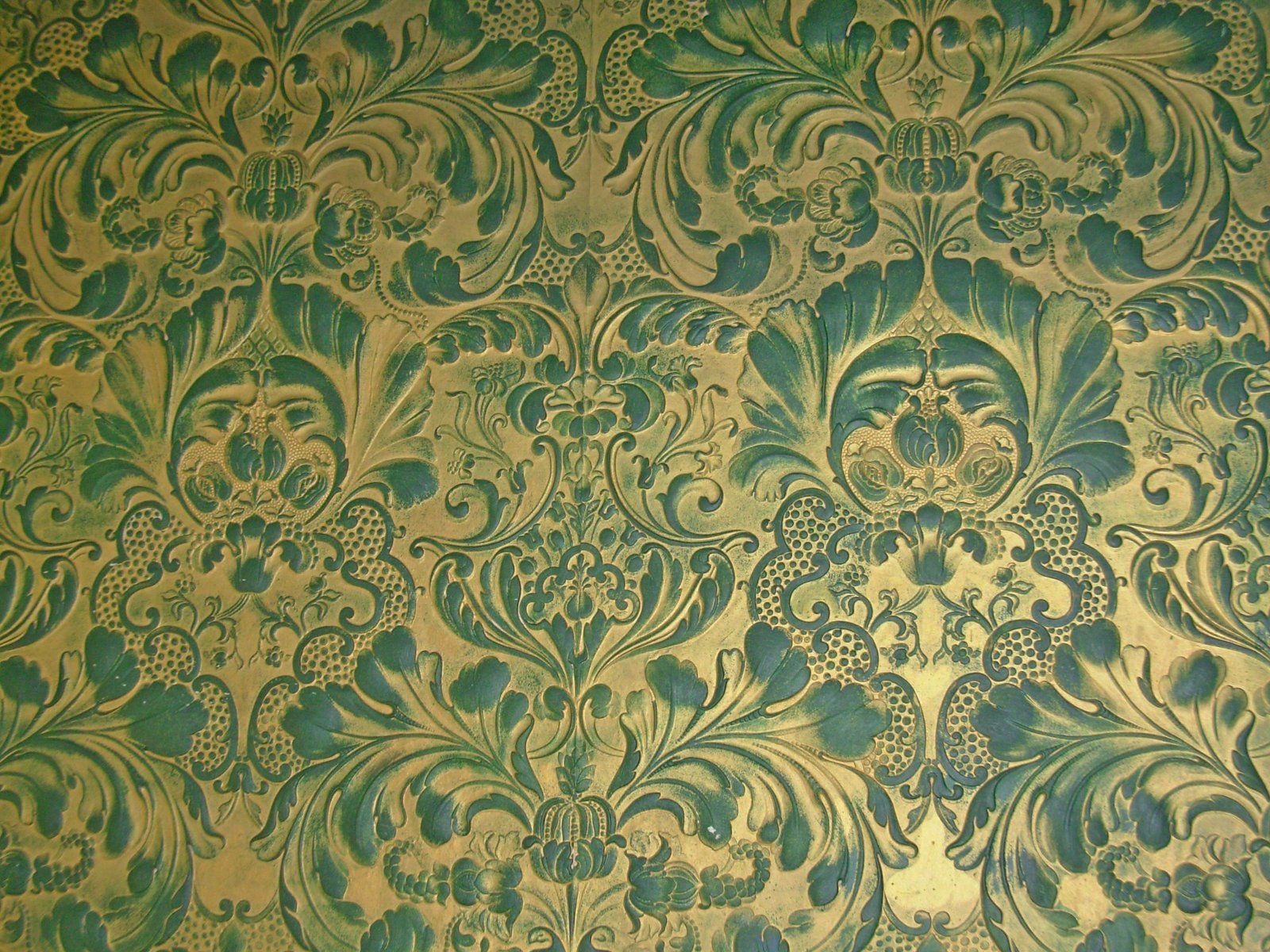 a gold colored wall with blue and green designs